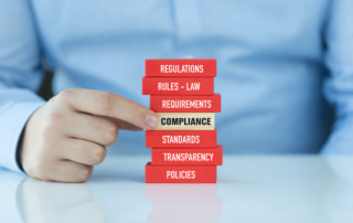Wooden blocks arranged to spell 'Compliance,' symbolizing the importance of adhering to professional standards and regulations in the appraisal industry.